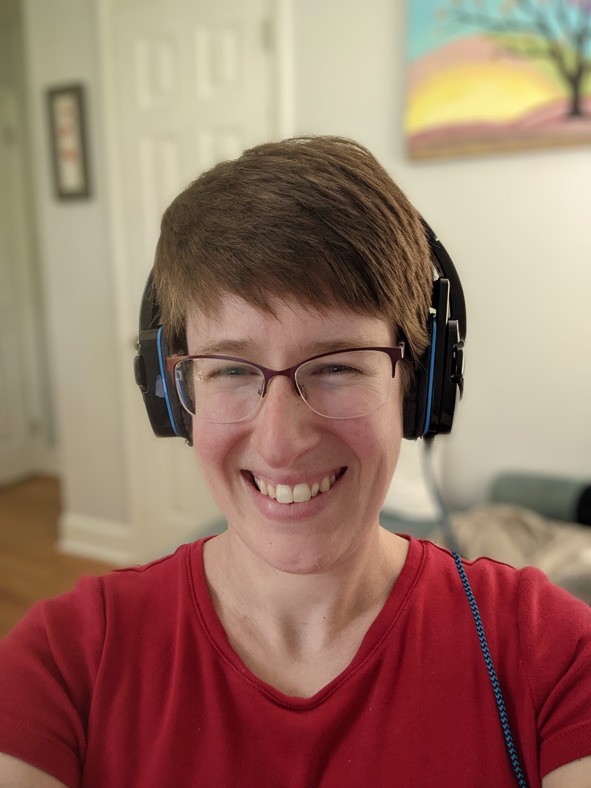 White person with short, brown hair wearing a red shirt and headphones